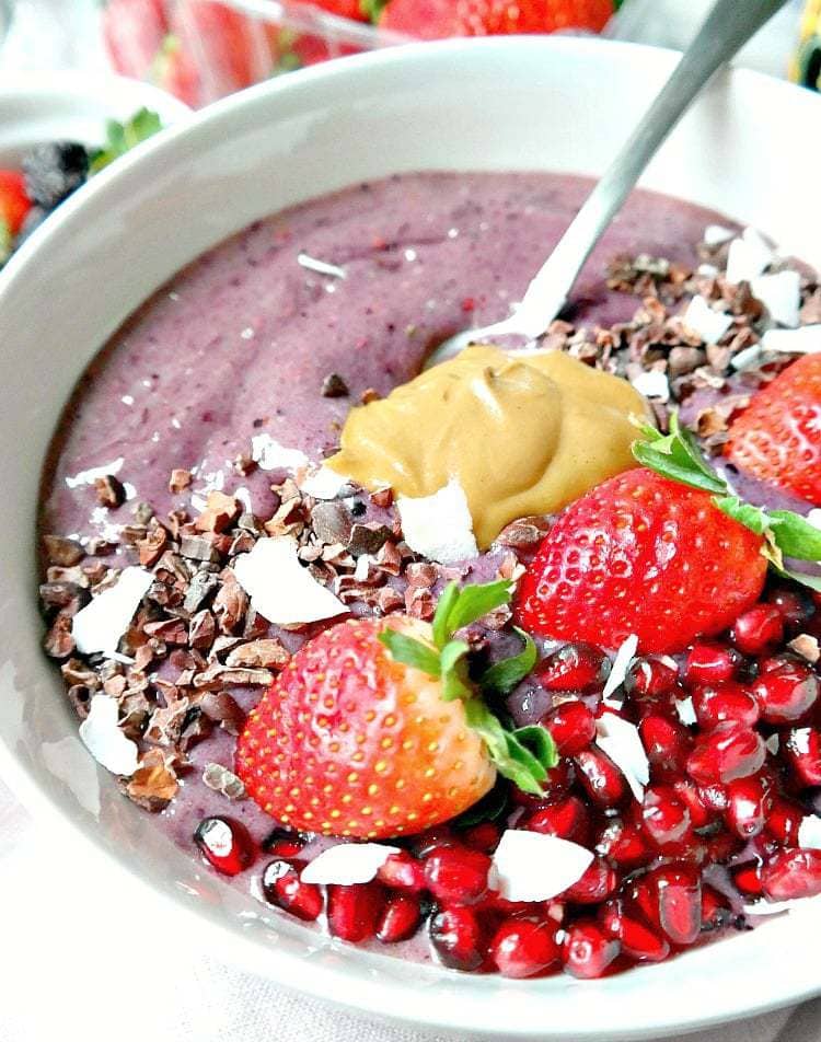 Dairy-free and Vegan 'Purple Power Smoothie Bowl' - loaded with antioxidants, omegas and fiber to keep you nourished and full. Decadently healthy with nut butter, cacao nibs, fresh fruit and superfoods, this is one powerful breakfast bowl! From The Glowing Fridge. #power #smoothie #bowl #vegan 