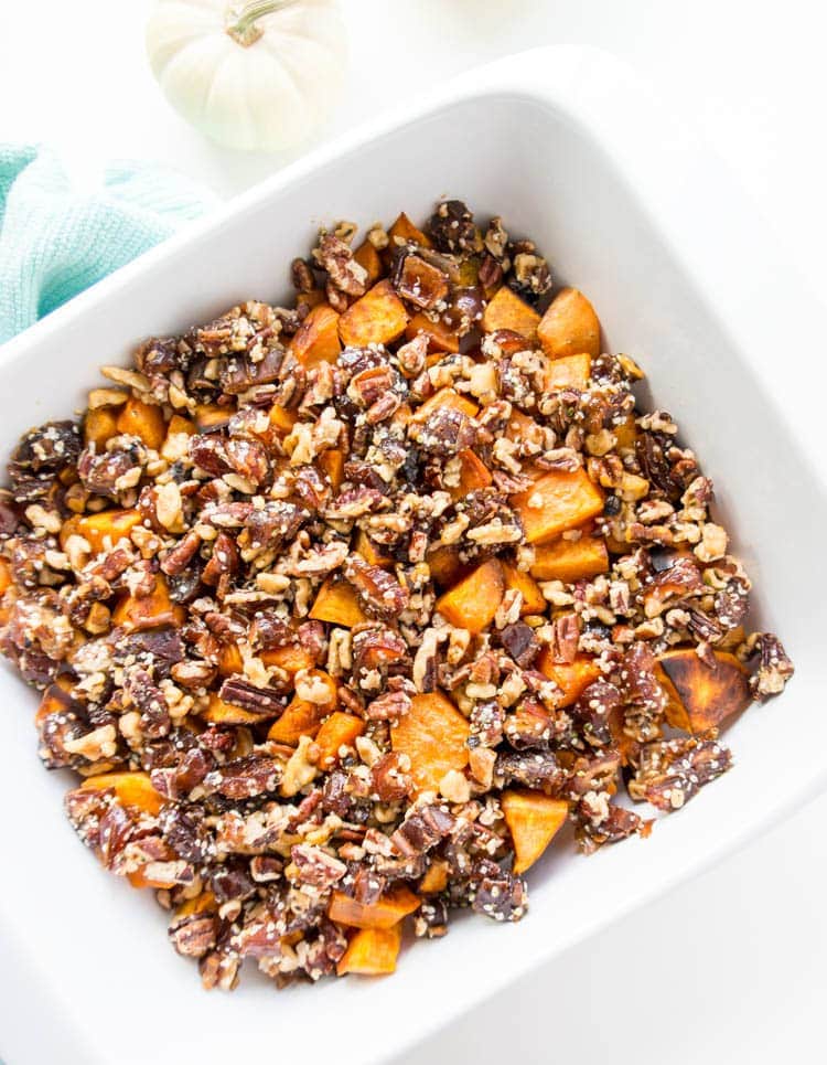 Roasted Sweet Potatoes with Maple Pecan Date Crumble. Vegan and Gluten Free! Melt in your mouth (yet crispy) sweet potatoes with a sticky, gooey and decadent crumble of pecans, walnuts, dates, maple syrup and cinnamon. This will be the highlight sweet potato side for Thanksgiving or any holiday! #vegan #sweetpotatoes #thanksgiving