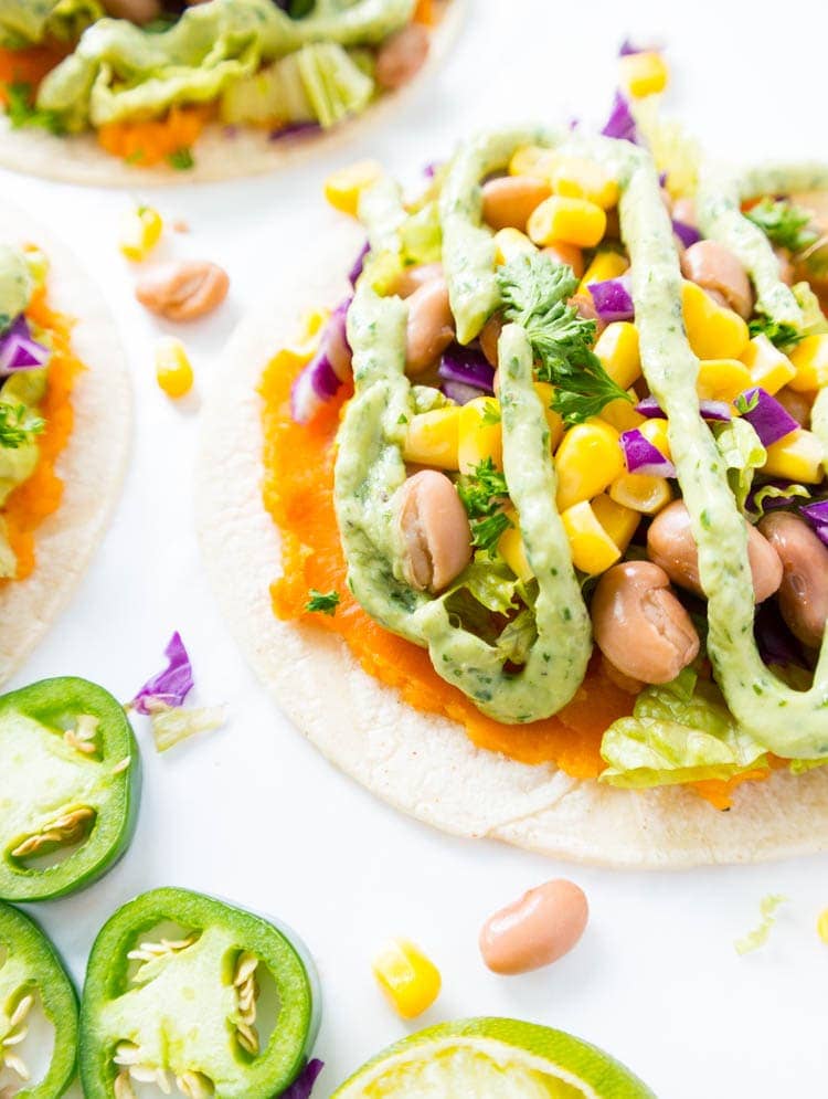 Roasted Sweet Potato Mash Tostadas. Vegan, Oil Free, Gluten Free. Clean, super simple and lots of fun to make! With a pinto bean & sweet corn mixture, all the toppings and a Spicy Magic Green Sauce. Healthy, satisfying and vibrant! #vegan #tostadas
