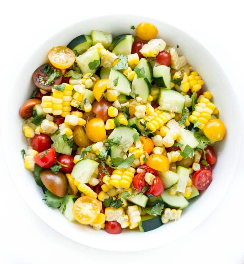 Summer Glow Salad. Super fresh and seasonal for summer with mini tomatoes, fresh corn and crisp cucumber with all the lime juice. Makes a perfect appetizer paired with tortilla chips and hummus, a side dish or served over kale and quinoa for lunch! #vegan #summer #glow #salad