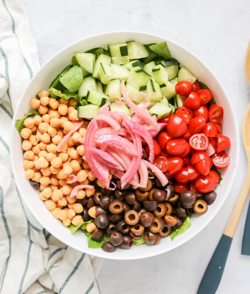 Greek Chopped Chickpea Salad with Spicy Vinaigrette. Vegan Greek Salad with cucumber, tomato, olives, chickpeas, pickled onion and pita chips! #vegan #greek #salad #spicy #dressing