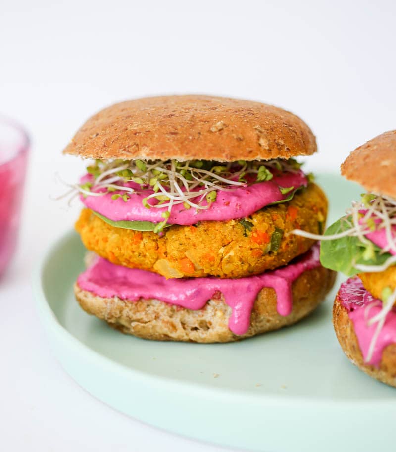 Turmeric Veggie Burgers with Tahini Beet Sauce. Golden and delicious vegan veggie patties with a pink tahini beet sauce that is out of this world! #vegan #veggie #burger #turmeric